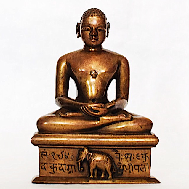 Escultura de Mahavira sentado en posición de loto sobre un trono.